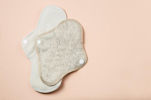 Reusable zero waste menstrual pads of differens size and textile on light beige background