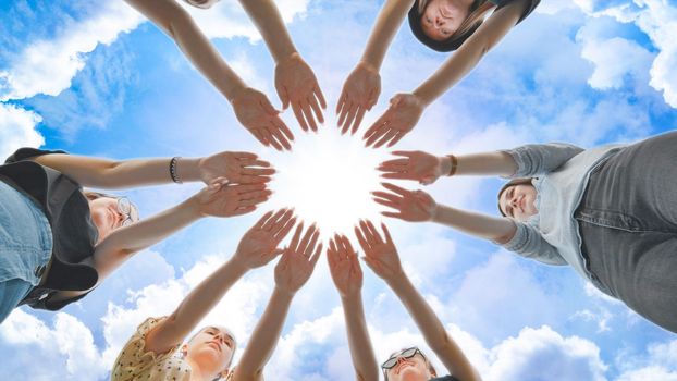 Girlfriends join the palms of their hands in the center making a circle shape