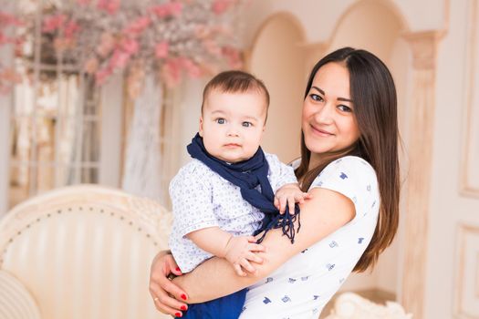 Portrait of young mother with cute baby at home.