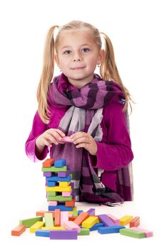 little girl playing with the wood game jenga on white background