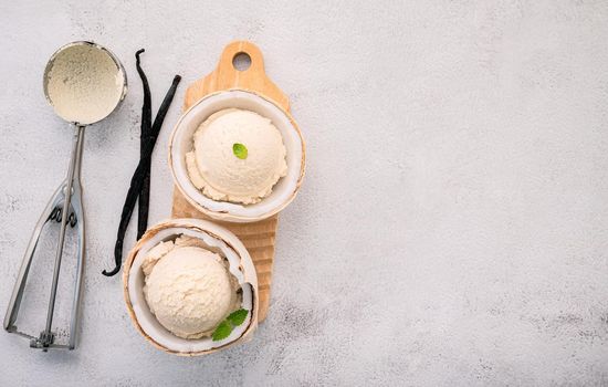 Coconut ice cream flavours in half of coconut setup on white stone background. Summer and Sweet menu concept.