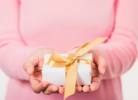 Valentine's Day. Woman beauty hands holding small gift package box present wrapped paper with ribbon isolated on white background, Birthday, New year, Christmas, holiday background concept