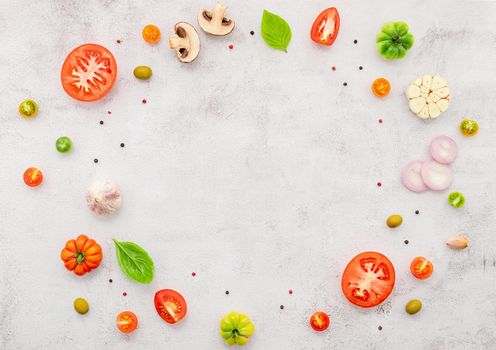 The ingredients for homemade pizza set up on white concrete background.