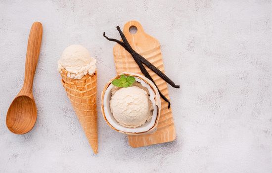 Coconut ice cream flavours in half of coconut setup on white stone background. Summer and Sweet menu concept.