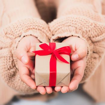 Valentine Day. Female beauty hands holding small gift package box present wrapped paper with ribbon isolated on white background, Christmas, New year, Birthday holiday background concept