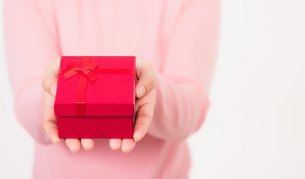 Valentine Day. Female beauty hands holding small gift package box present wrapped paper with ribbon isolated on white background, Christmas, New year, Birthday holiday background concept