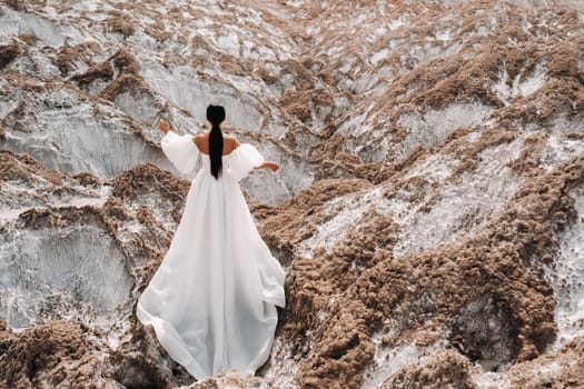 A beautiful unrecognizable bride in a wedding dress on top of the salty mountains. The wedding day. Beautiful portrait of the bride without the groom.