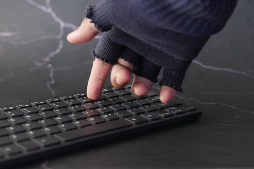 hacker hand stealing data from laptop top down.