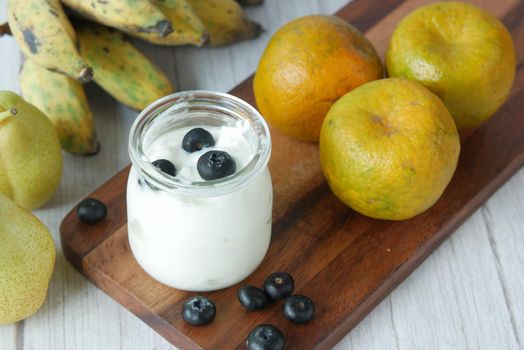 close up of fresh yogurt with blue berry in a bowl .