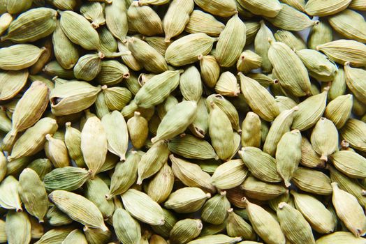 close up of Cardamom on a spoon on table .