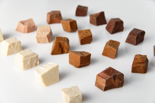 Pieces of different milk chocolate on white background.