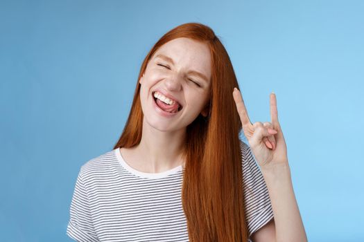 Lifestyle. Happy cheerful carefree chilling redhead teenage girl having fun stick tongue close eyes dancing joyfully show rock-n-roll heavy metal sign enjoy party amusing festival music performance.