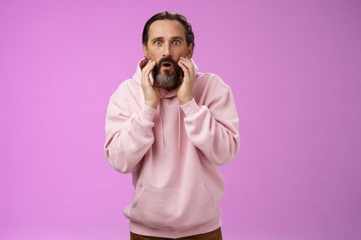 Impressed surprised handsome adult bearded man grey hair attend barber shop cannot believe see own reflection become stylish cool-looking touching face amused fascinated widen eyes amazement. Lifestyle.