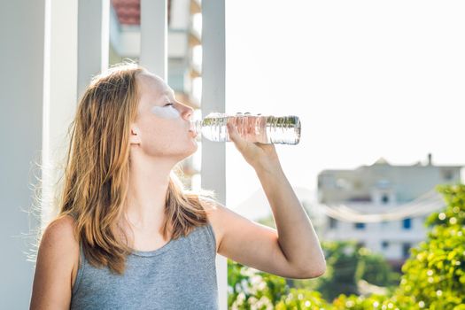 Portrait of Beauty Red-haired woman with eye patches drinks water. Spa Girl.