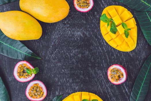 Mango and passion fruit on an old wooden background. Copy space.