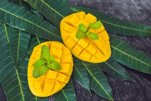 Mango and mango leaves on an old wooden background.