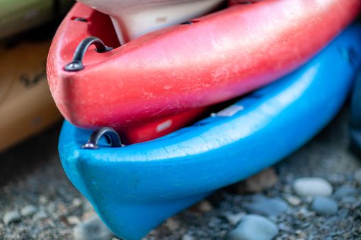 Close up shot of several Kayaks stowed by the sea shore.