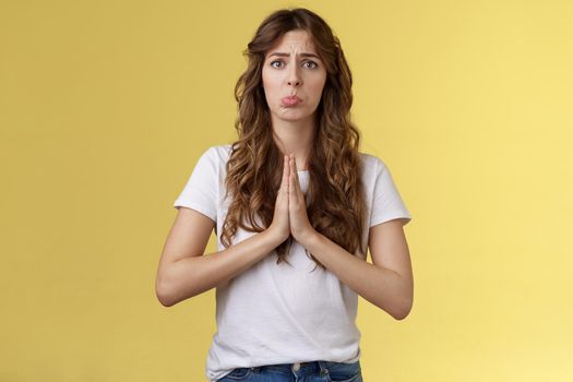Pretty please need help asap. Sad cute get pity sobbing pulling begging face hold hands pray supplicating pleading offer frowning innocent timid expression stand yellow background. Copy space