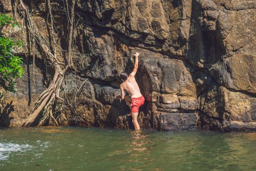 A man climbs up a mountain from the water.