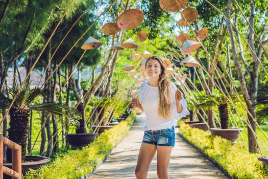 Young woman tourist and Vietnamese hats. Travel around Vietnam concept.