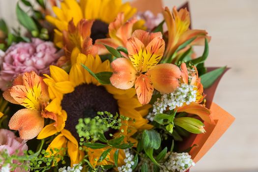 Fresh Bouquet of yellow sunflowers and pink carnations with white wood background