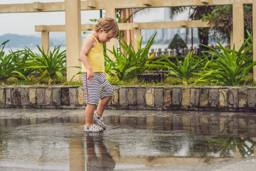 Little boy runs through a puddle. summer outdoor.