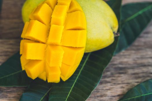 Mango and mango leaves on an old wooden background.