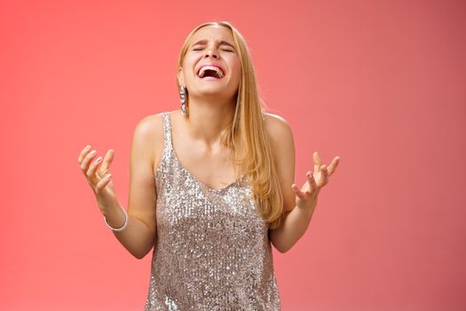 Relieved happy charming blond woman thank god shouting yes celebrating rejoicing win standing red background close eyes laughing happiness clench fists victory triumph gesture, dream came true.