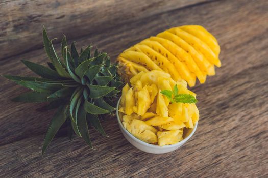 Pineapple and pineapple slices on an old wooden background.