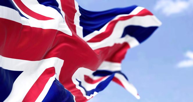 Three national flag of the United Kingdom flying in the wind on a bright day. Selective focus