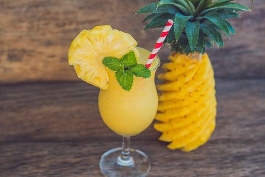 Pineapple and pineapple smoothies on an old wooden background.