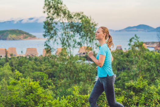 A sportive young woman is engaged in running against the sea.