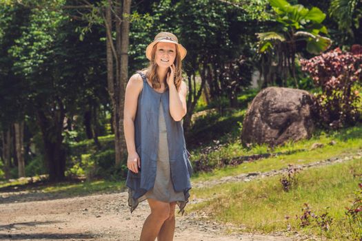 A young woman is walking along a forest road.