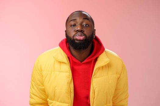 Portrait bored childish cute african bearded 25s male show tongue grimacing making funny faces immature behaviour unwilling grow-up standing pink background mimicking folding lips tube.
