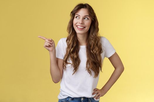 Dreamy silly tender caucasian girl picking making choice shopping together friend smiling curious satisfied found perfect variant look pointing upper left corner thoughtful interested grin delighted. Lifestyle.