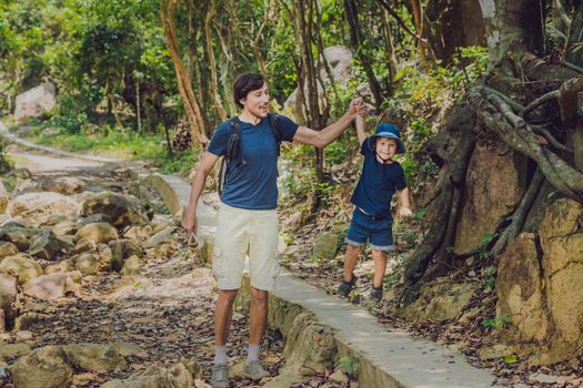 Father and son are walking along the forest road.