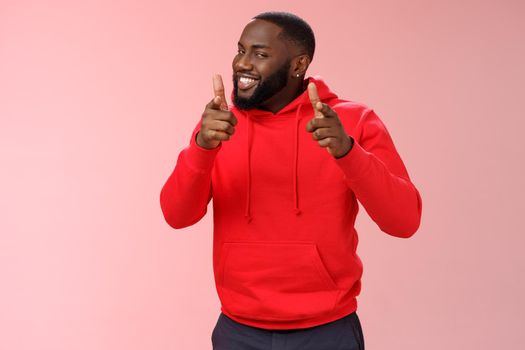 Nice work well done friend. Proud cheering good-looking cheeky young flirty black guy beard in red hoodie pointing finger pistols camera smug congratulating mate good game, standing pink background.