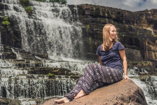 Young woman hiker, tourist on the background of Amazing Pongour Waterfall is famous and most beautiful of fall in Vietnam. Not far from Dalat city estimate 45 Km. Dalat, Vietnam.