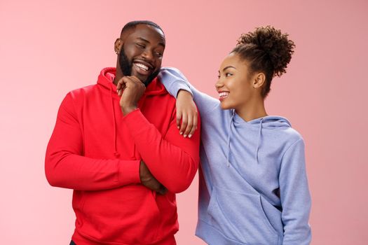 Two best friends having fun man smiling woman leaning his shoulder talking laughing joking like spending time together, standing pink background chit-chat confident relaxed poses. Copy space