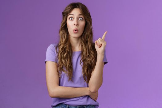 Got it eureka. Excited enthusiastic creative cute european girl raise index finger folding lips wow great found solution suggest perfect plan stand purple background thrilled give good advice.