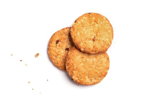 Scattered crumbs and three vanilla chip butter cookies isolated on white background. Close-up view of brown crackers. Macro shot of yellow biscuit cake leftovers for your design