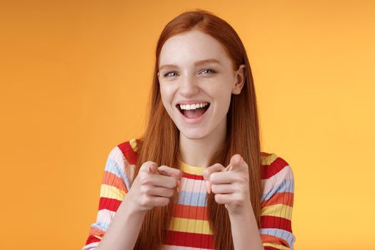 Enthusiastic carefree friendly redhead girl pointing finger-pistols camera smiling joyfully congratulating friend awesome choice cheeky greeting hinting girlfriend caught good opportunity.