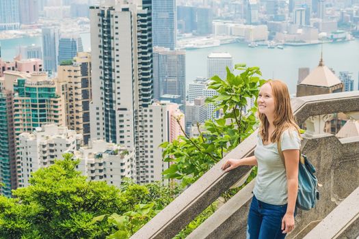 Young woman traveler at the peak of Victoria against the backdrop of Hong Kong.