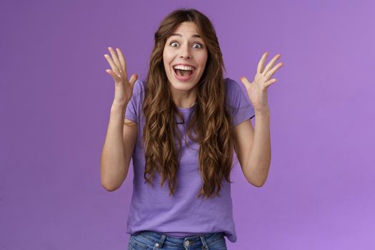 Cheerful surprised happy girl receive unbelievable super prize winning triumphing smiling joyfully shake hands excitement joy celebrating perfect news grinning happily victory purple background.