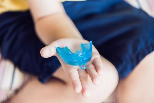 Three-year old boy shows myofunctional trainer to illuminate mouth breathing habit. Helps equalize the growing teeth and correct bite. Corrects the position of the tongue.