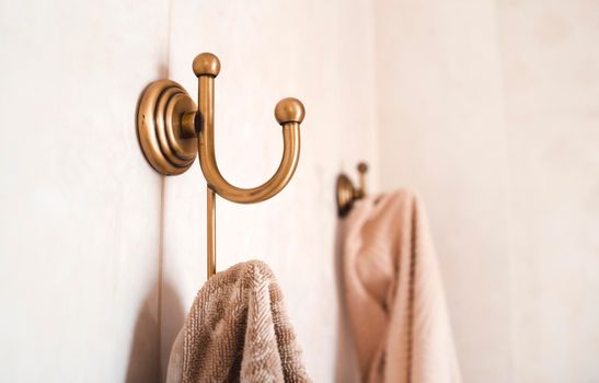 Towels hang on vintage stylish bathroom hooks in light shades.