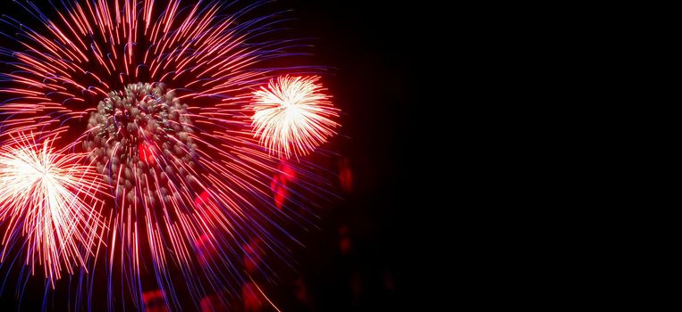 Flash of red and white fireworks on background black sky. Concept of holiday. Close-up, banner, copy space.