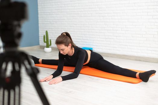 girl shoots a stretching and twine workout on camera