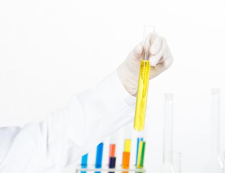 Analysis and synthesis in laboratory. Doctor hand in latex medical gloves holding test tube with liquid substance. Science laboratory research and development. Medicaments and vaccine testing.