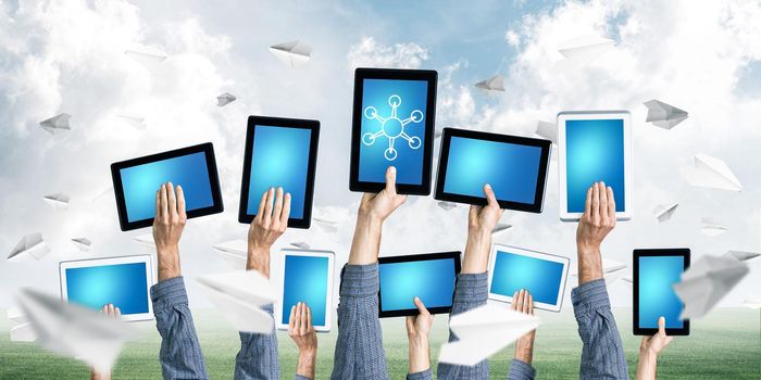 Set of tablets in male hands against nature background and paper planes in air